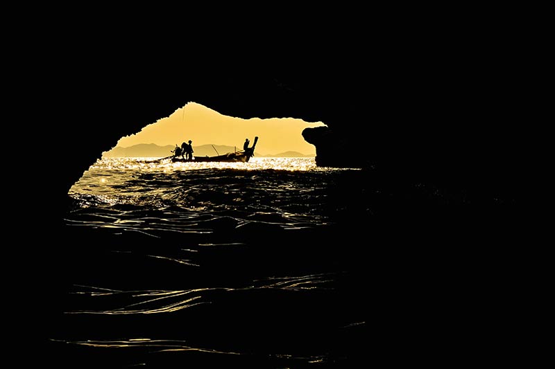 Opnieuwe en natuurlijk kader en het water op de voorgrond geven deze foto een mooie diepte bij het silhouet van de visser
