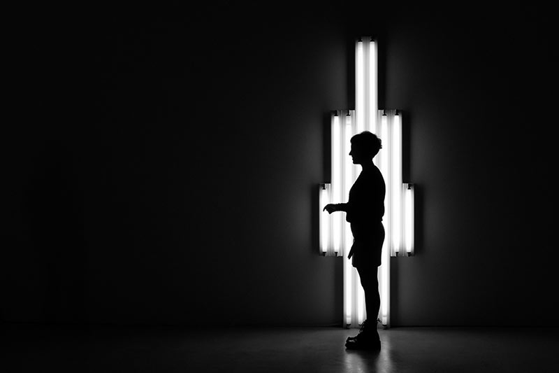Silhouet foto van een staande man met lampen op de achtergrond